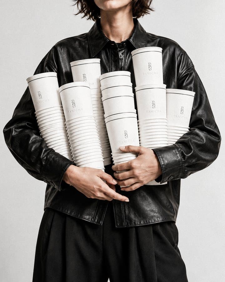 A model in black holding a stack of TANICHA cups